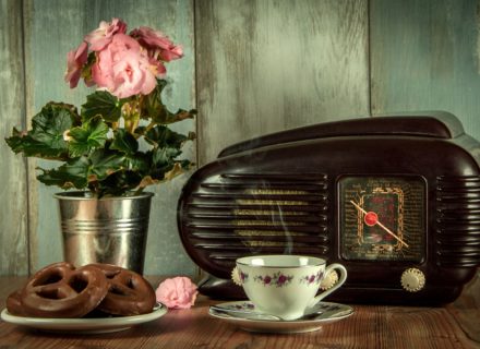 old fashioned radio on a kitchen table with donuts and coffee