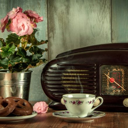 old fashioned radio on a kitchen table with donuts and coffee