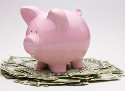 piggy bank sitting on cash